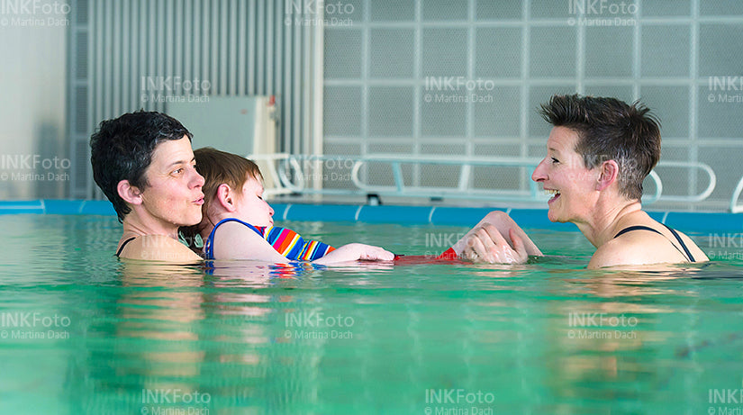 Frau mit Sehbehinderung zusammen mit 2 weiteren Frauen im Schwimmbad.