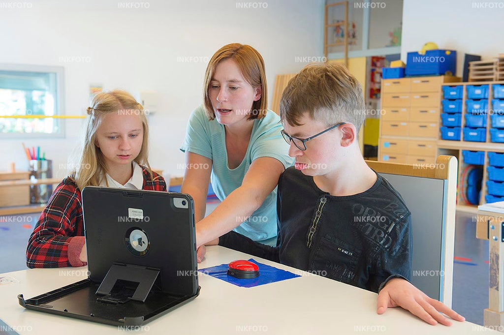 2 Kinder beim Unterricht mit einer Lehrerin.