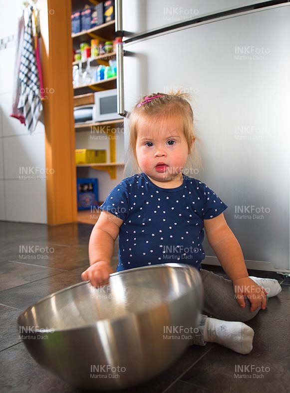 Kleines Mädchen mit Salatschüssel in der Küche