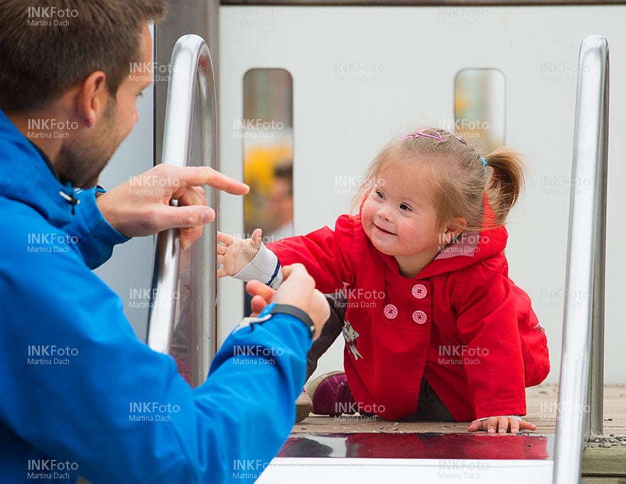 Kleines Mädchen auf der Rutsche mit Vater