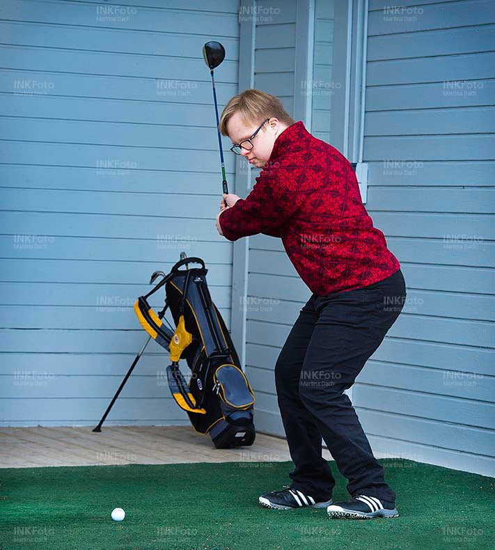 Junger Mann mit Behinderung spielt Golf