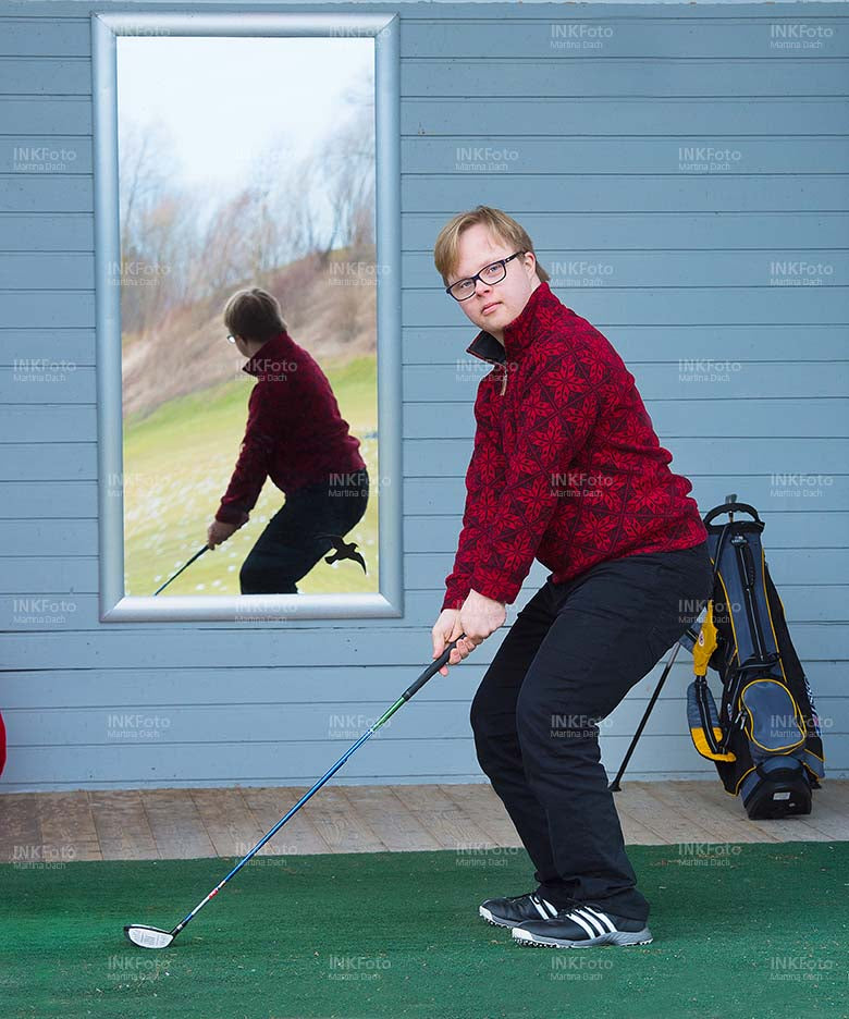 Junger Mann mit Behinderung spielt Golf