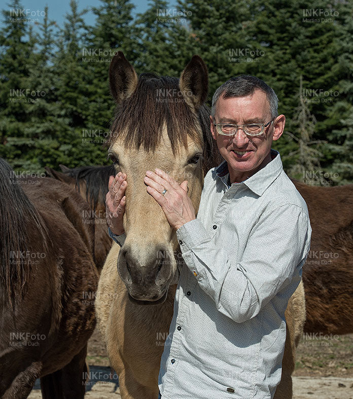 Mann mit Pferd auf einer Weide
