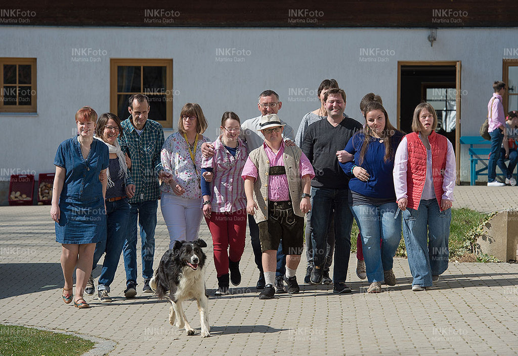 Fröhliche Gruppe von Menschen auf einem Bauernhof.