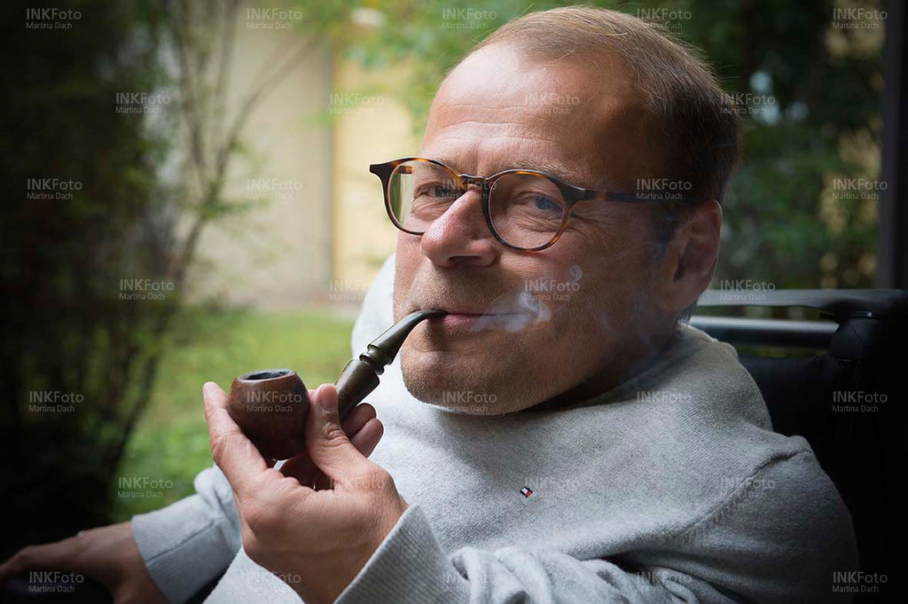 Portrait Mann im Rollstuhl Pfeife rauchend