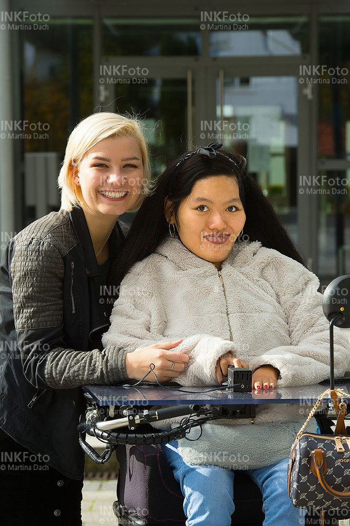 2 junge Frauen vor einer Behörde.