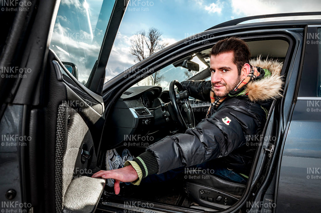 Junger Mann beim Aussteigen aus dem Auto.