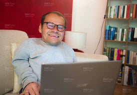 Lächelnder Mann mit Laptop im Homeoffice bei der Arbeit