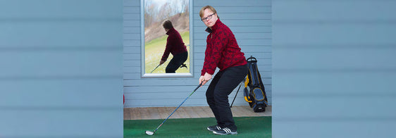 Junger Mann mit Behinderung spielt Golf