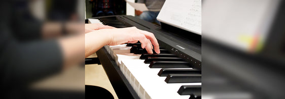 Junge Frau im Rollstuhl spielt Klavier
