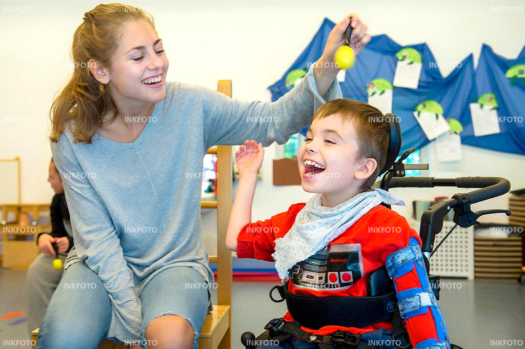 Lehrerin und Schulkind mit Rassel im Unterricht.