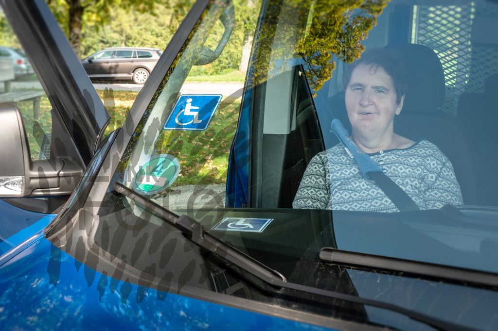 Frau mit Behinderung auf dem Beifahrersitz im Auto