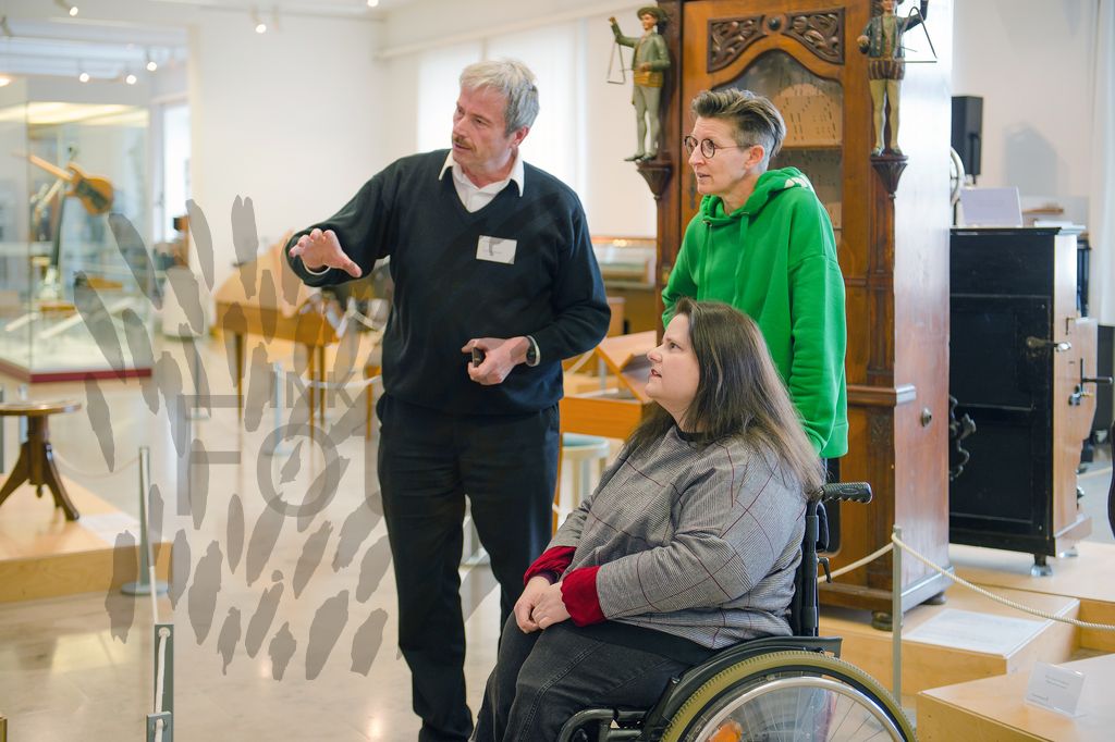 Frau im Rollstuhl mit Mann und Frau im Musik-Museum