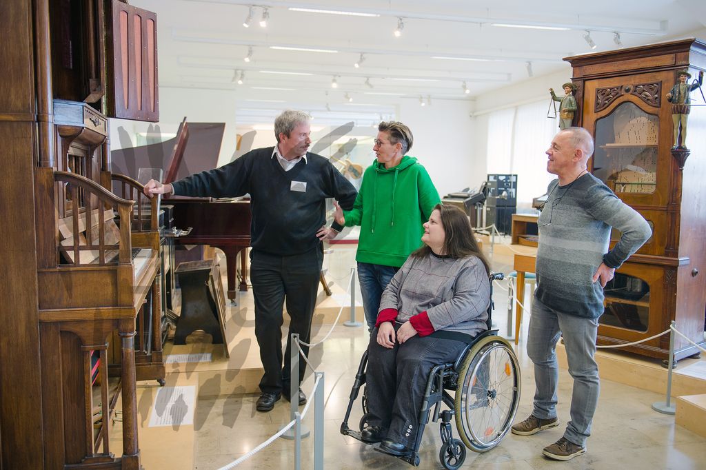 Frau im Rollstuhl mit 3 weiteren Personen im Musik-Museum