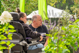 Mann und Frau im Rollstuhl sitzen im Garten