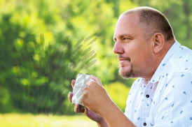 Mann mit Hörgerät trinkt Kaffee im Garten