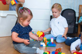 Kleinkinder mit und ohne Behinderung spielen Lego