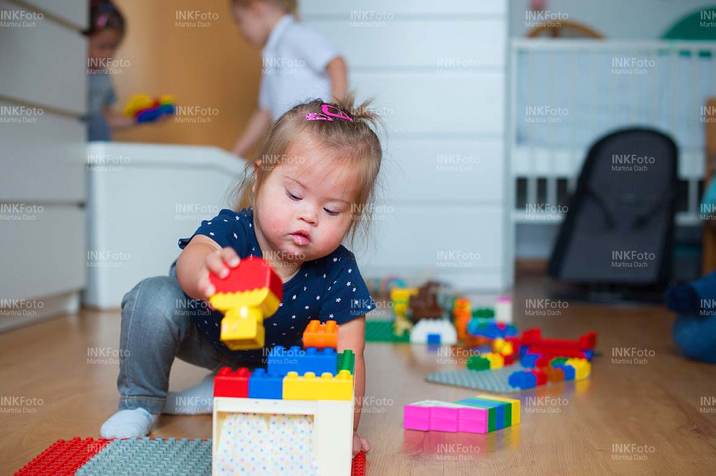 Kleinkind mit Behinderung spielt Lego