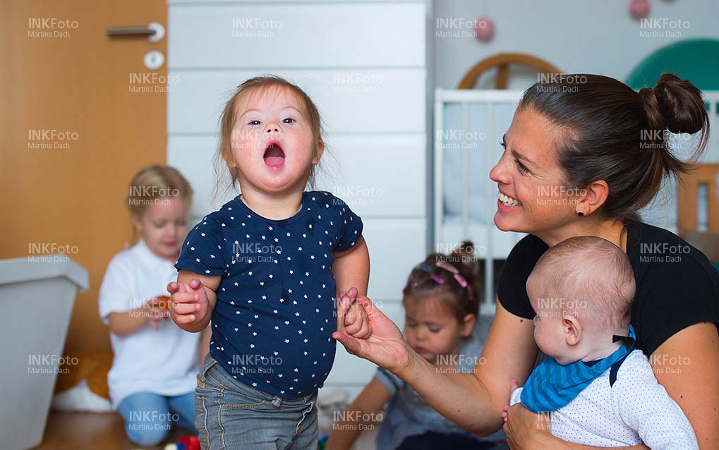 Mutter mit Kleinkindern mit und ohne Behinderung beim spielen