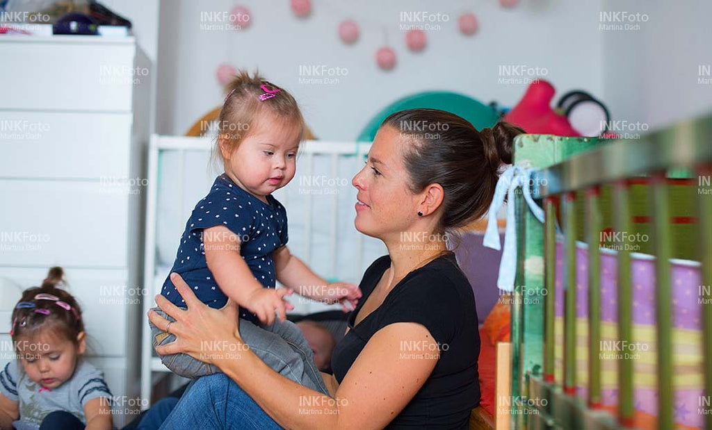 Mutter mit Kleinkind mit Behinderung im Kinderzimmer