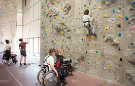 Junge Menschen im Rollstuhl an der Kletterwand