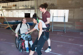 Junger Mann im Rollstuhl erhält Unterricht im Klettern