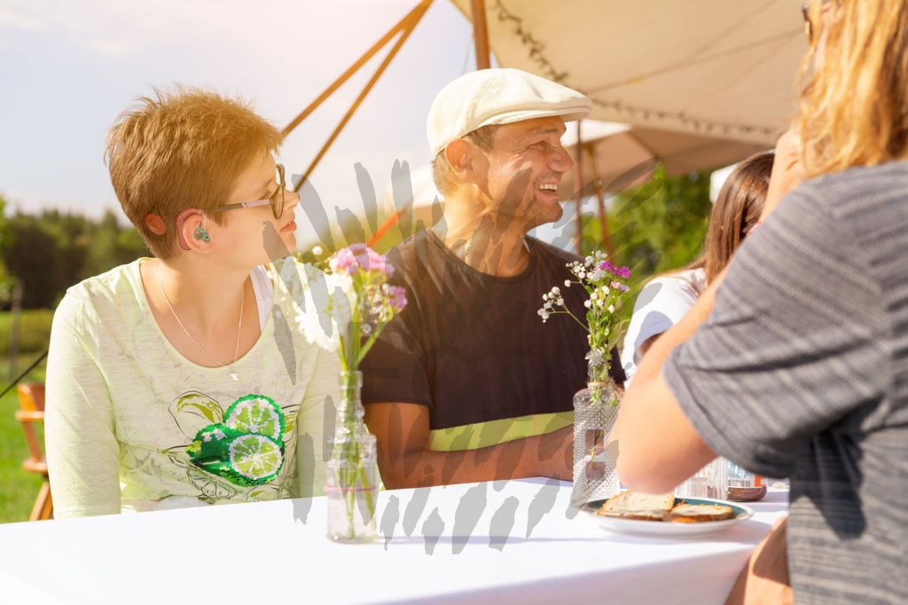 Fröhliche junge Menschen mit und ohne Behinderung bei einem Gartenfest