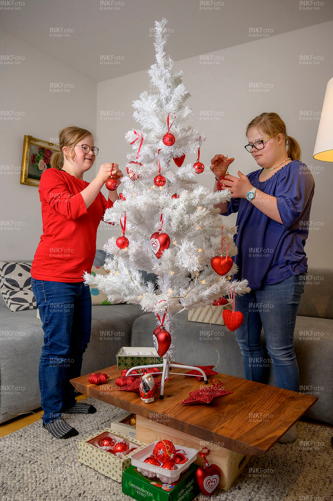 2 junge Mädchen schmücken einen Weihnachtsbaum