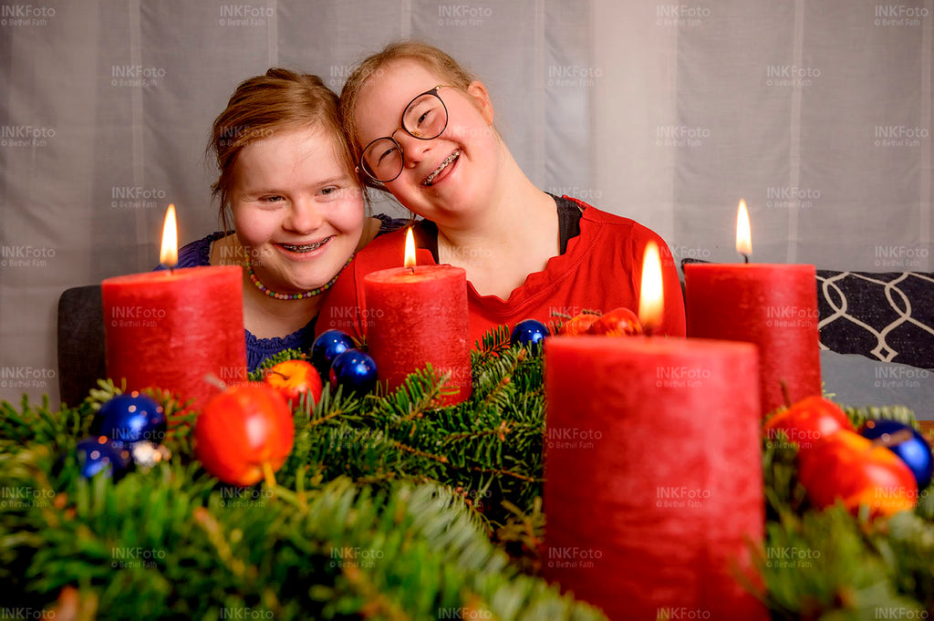 2 junge Mädchen vor einem Adventskranz