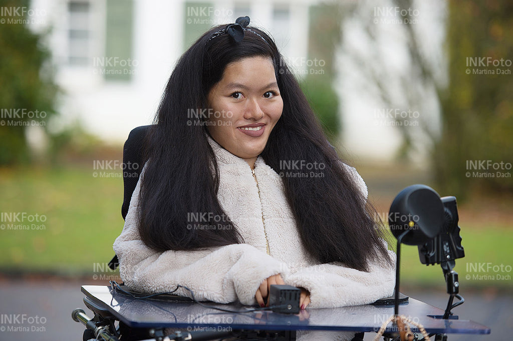 Junge Frau im Rollstuhl beim Spaziergang.