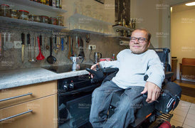 Mann im Rollstuhl in der Küche